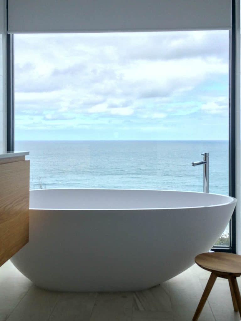 Motorised Roller blind in bathroom with seaview by SOM Blinds